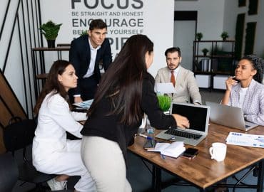 Employee discussing outsourcing projects to team of 4